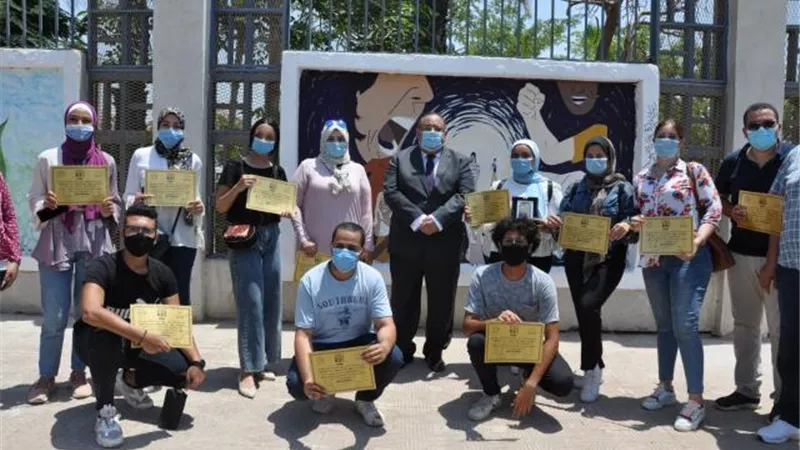 بالصور .. تجميل سور جامعة حلوان بلوحات إبداعية بأيدي طلاب كلية التربية الفنية