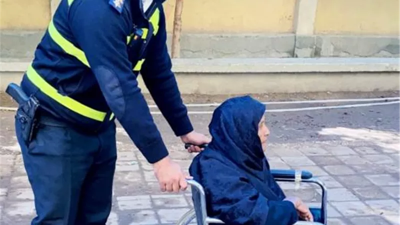 بكرسى متحرك .. نقيب يساعد مُسنة أثناء العملية الانتخابية بقنا